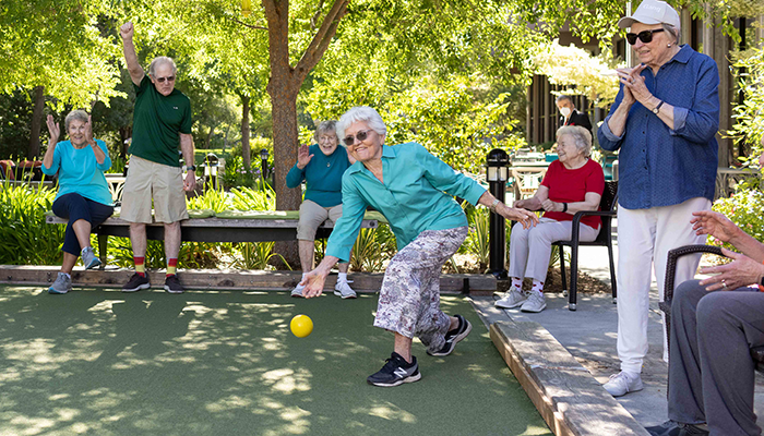 A woman about to roll a bocce ball