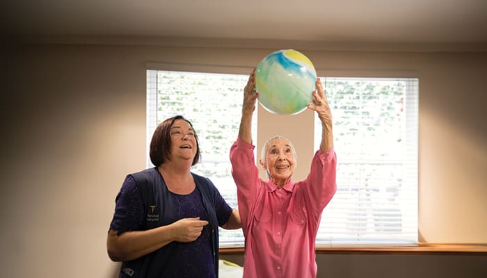 Rehab therapist with resident holding a ball