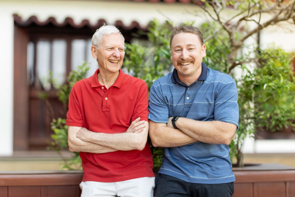 Portrait of man and senior man smiling outdoors