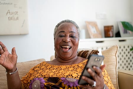 Smiling senior woman having video call on smart phone at home