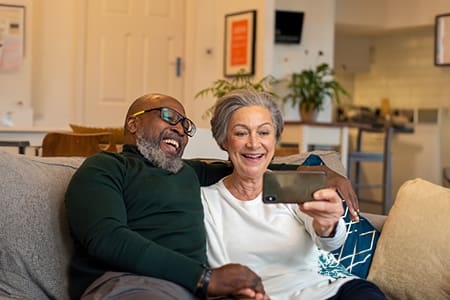 Portrait of elderly couple watching a video on a mobile phone