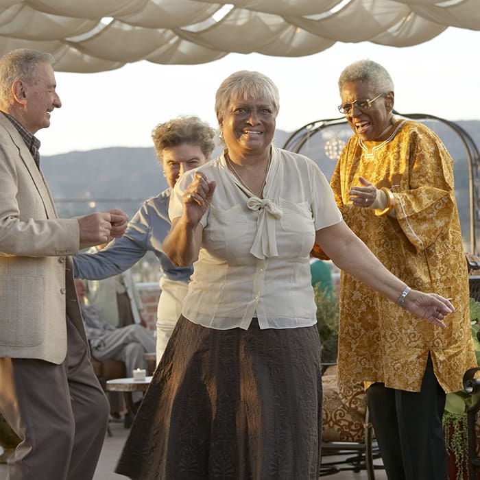 Portrait of a group dancing on the Kingsley Manor rooftop