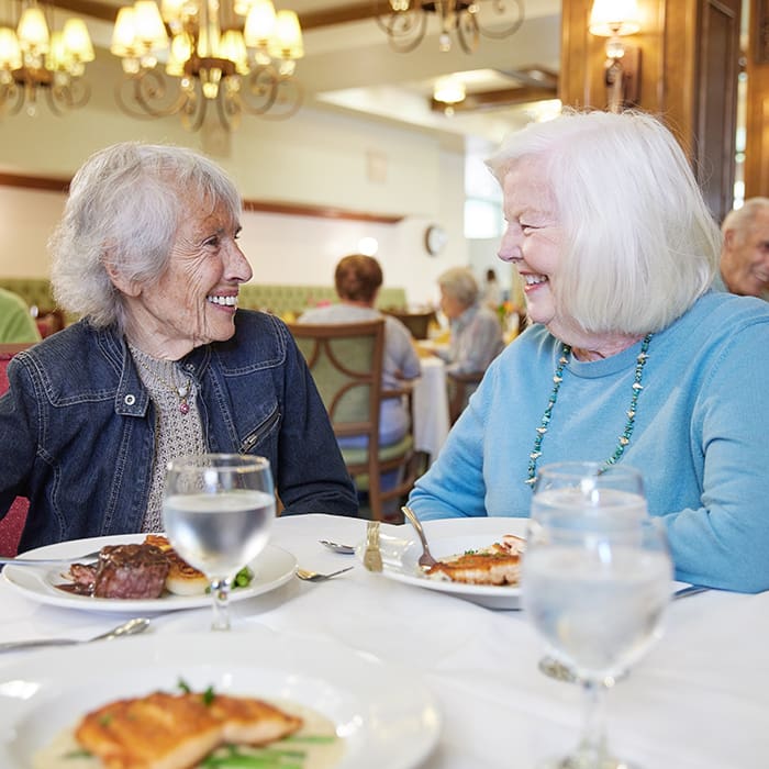 Portrait of smiling women enjoying dinner at Kingsley Manor