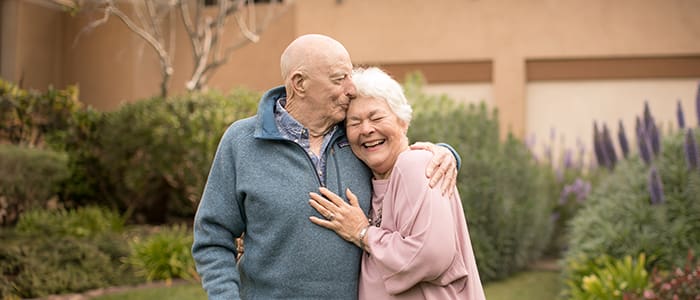 Elderly couple embracing outdoors