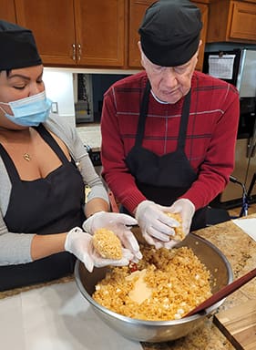 A Summer House staff member and resident enjoy making cookies.