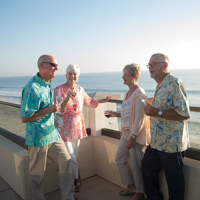 Senior residents gathering outdoors and enjoying drinks at Carlsbad by the Sea