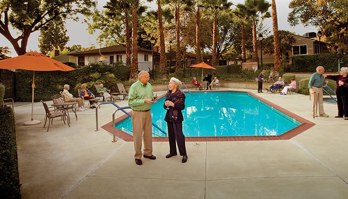 Two people standing in front of an outdoor pool