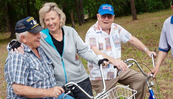 Photograph of smiling group outdoors on bicycles