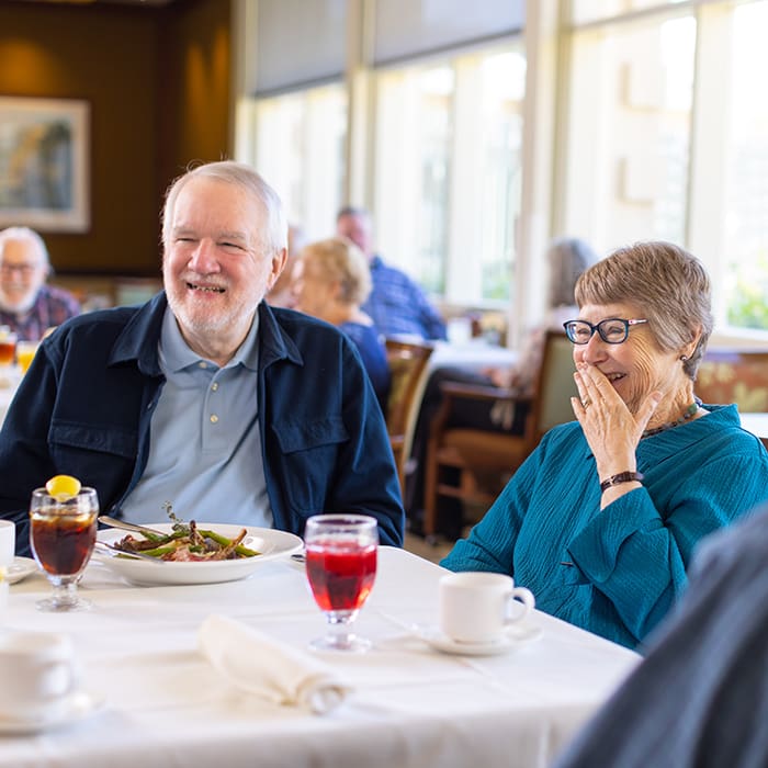 Residents smiling in the Canterbury Woods dining room