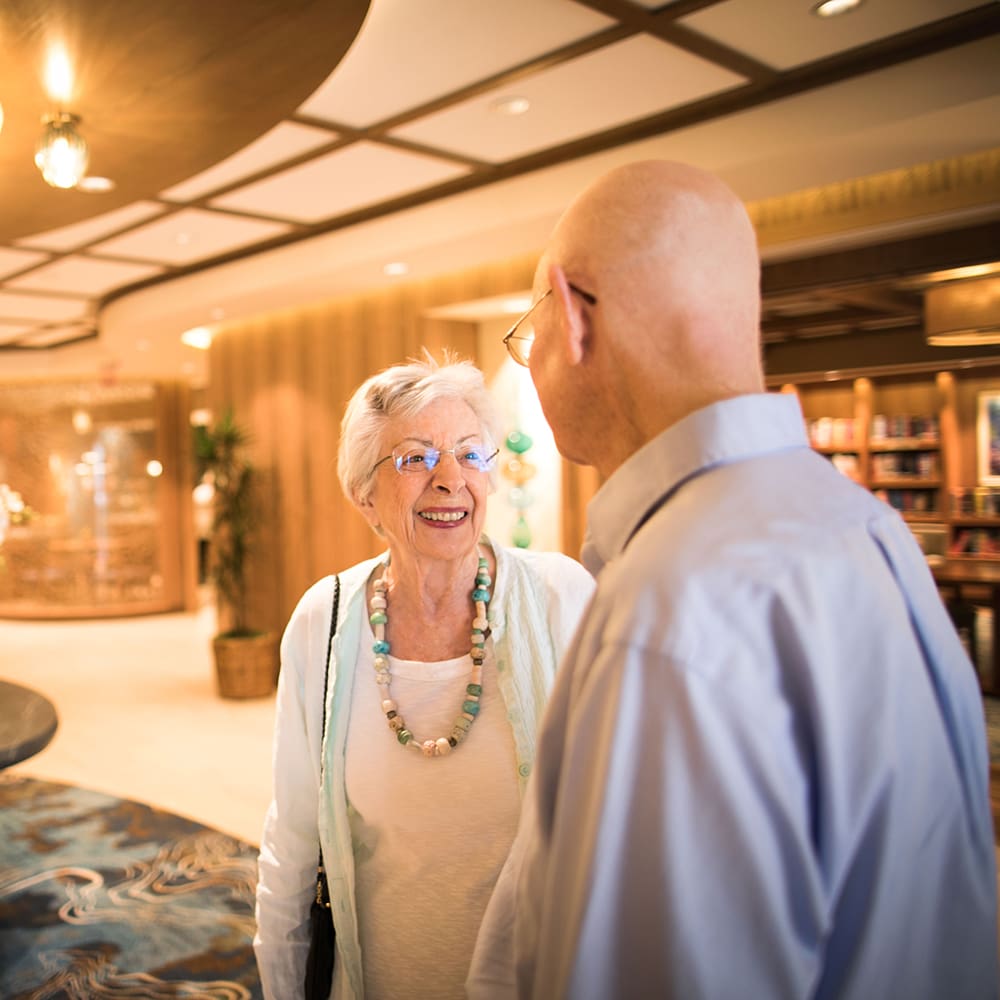 Two residents greeting each other in the Villa Gardens lobby