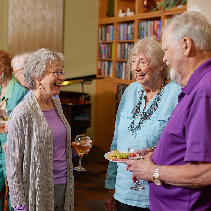Group of three residents chatting at Webster House