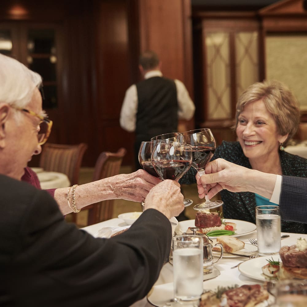 Residents toasting while dining in San Francisco Towers dining room