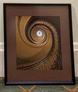 A framed photograph looking up a spiral staircase