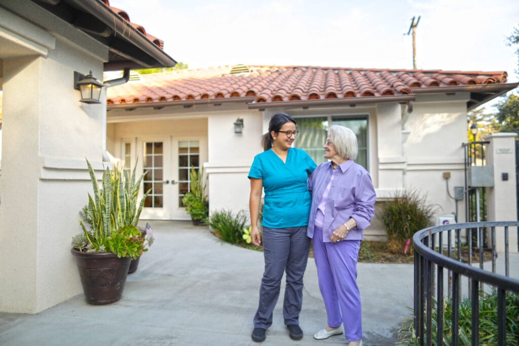 A resident and nurse smile at each other. 