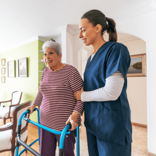 nurse helping elderly lady with a walker