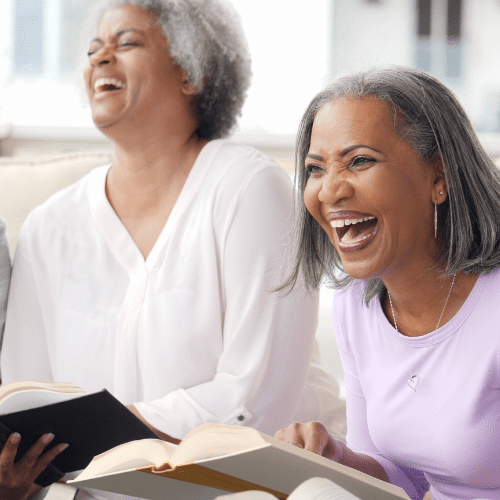 ladies laughing at a book they are reading