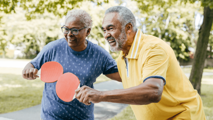 an elderly couple playing ping-pong