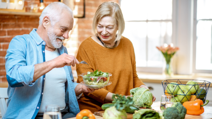 a couple of seniors preparing a salad