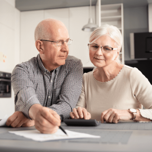 elderly couple signing a paper