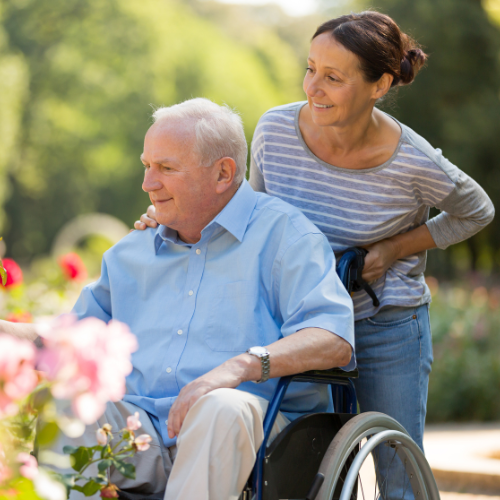 Woman pushing elderly man in a wheelchair