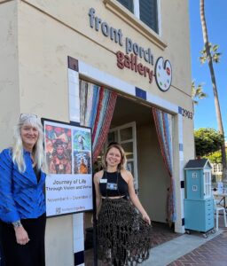 Two women stand in front of a building with the sign Front Porch Gallery.