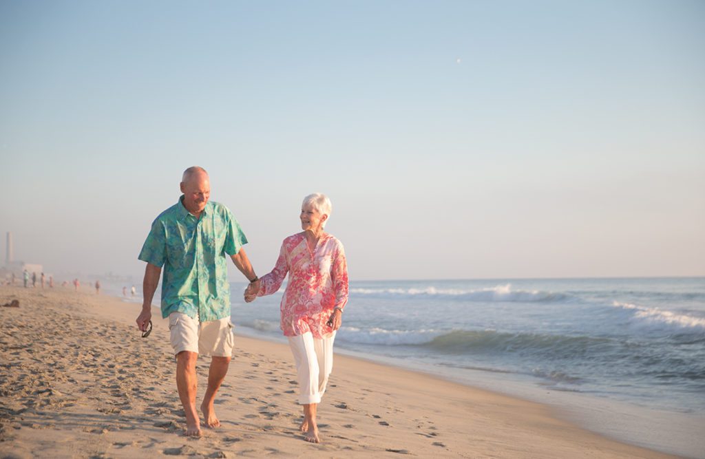 old couple walking on the beach