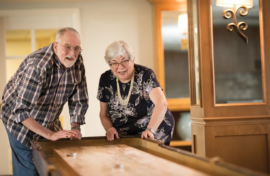 a couple of seniors playing shuffleboard