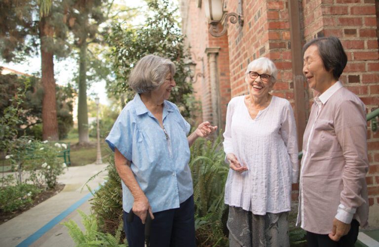 three ladies smiling at each other