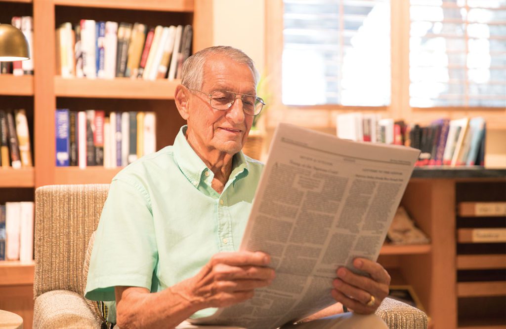 a senior men reading a newspaper