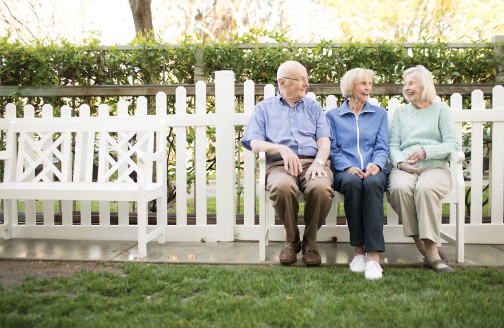 a group of seniors having a conversation and smiling each other