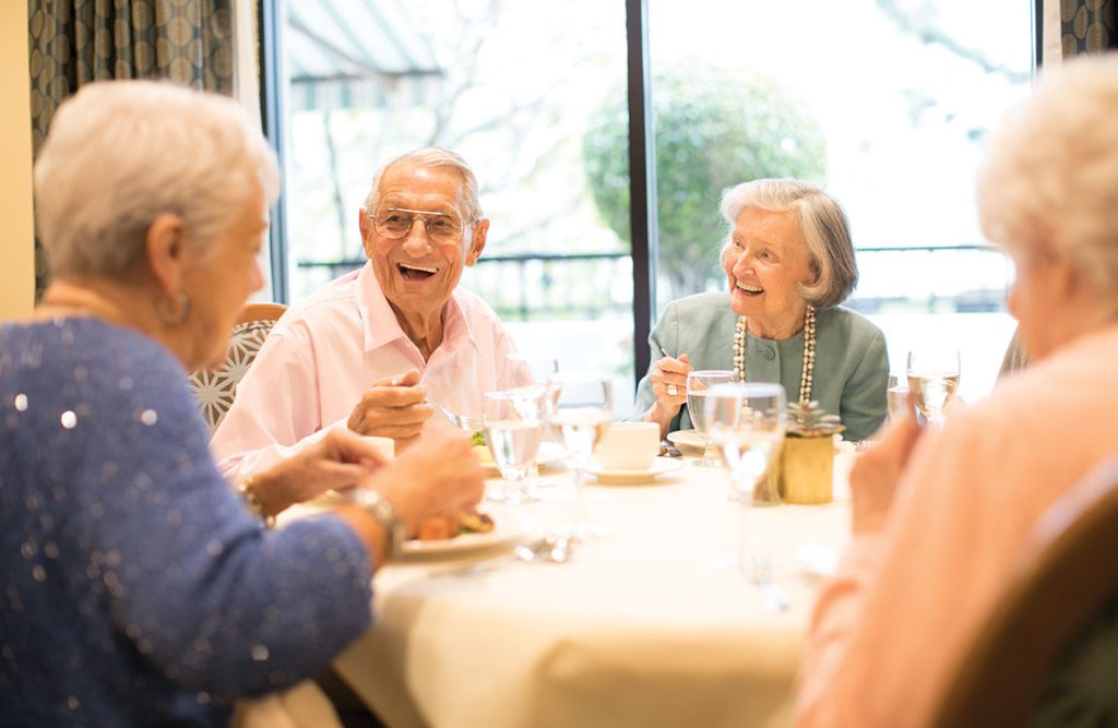 a group of seniors having a conversation and smiling each other