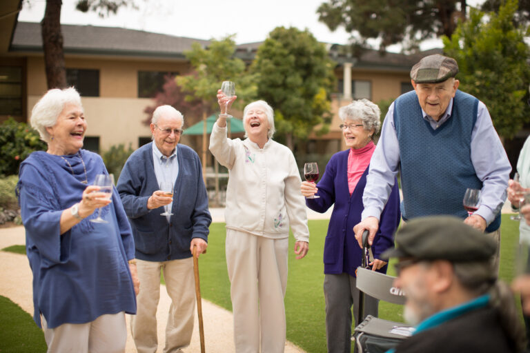 Group of residents outside of Vista de Monte enjoying drinks