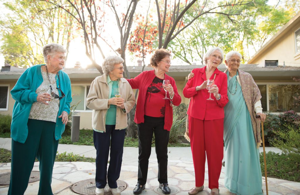 Group photo of senior women enjoying a glass of wine outdoors at Summer Villa