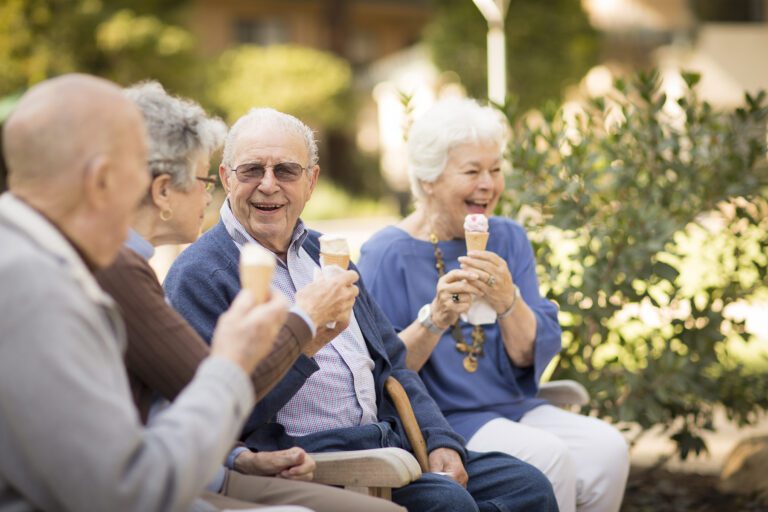 a group of elderly people sharing together and eating ice cream