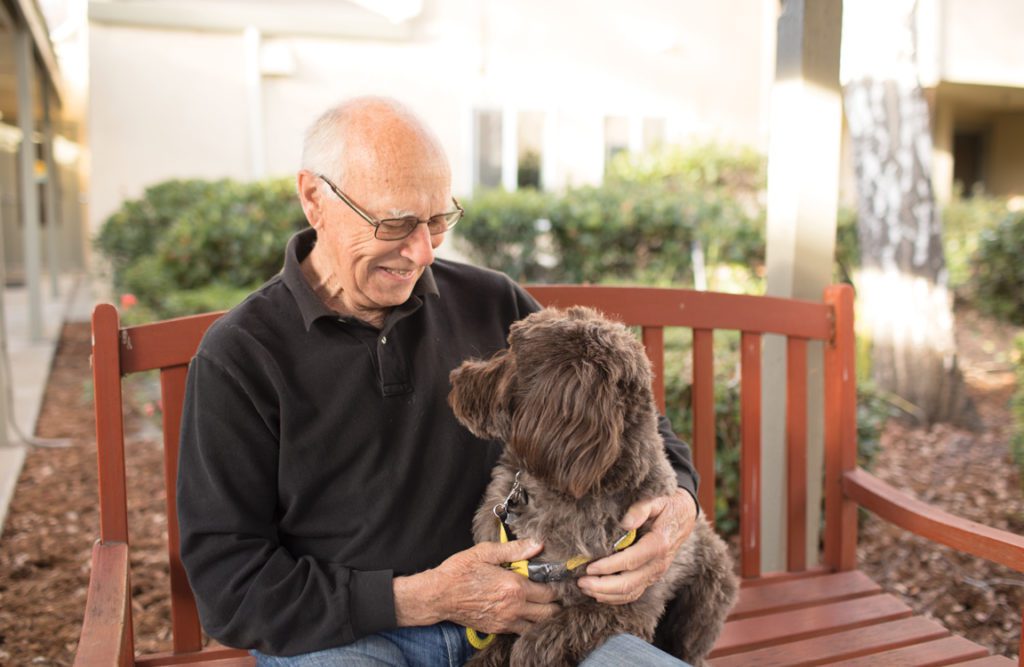 an old man petting his dog