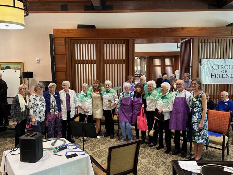 A group of people gather in a room, posing in a line.