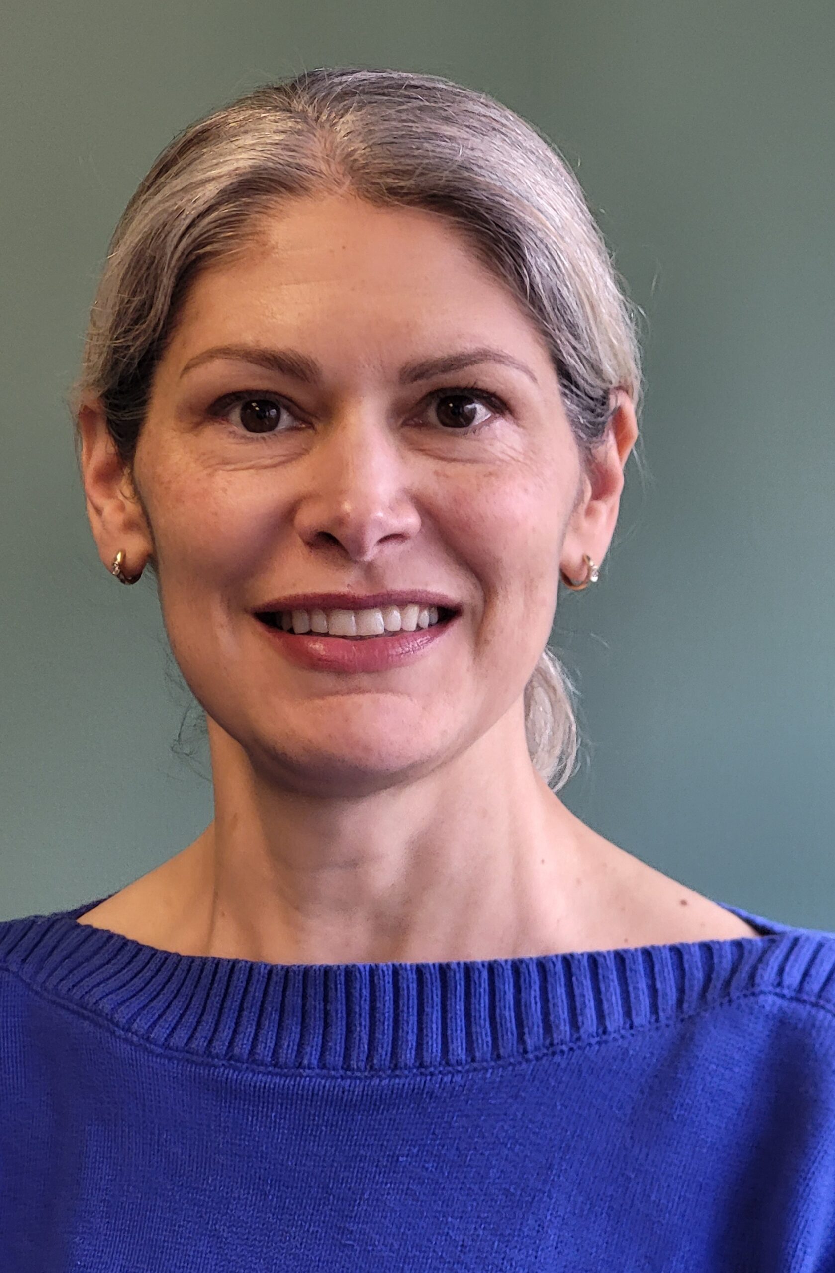 A headshot of a woman wearing a blue sweater.