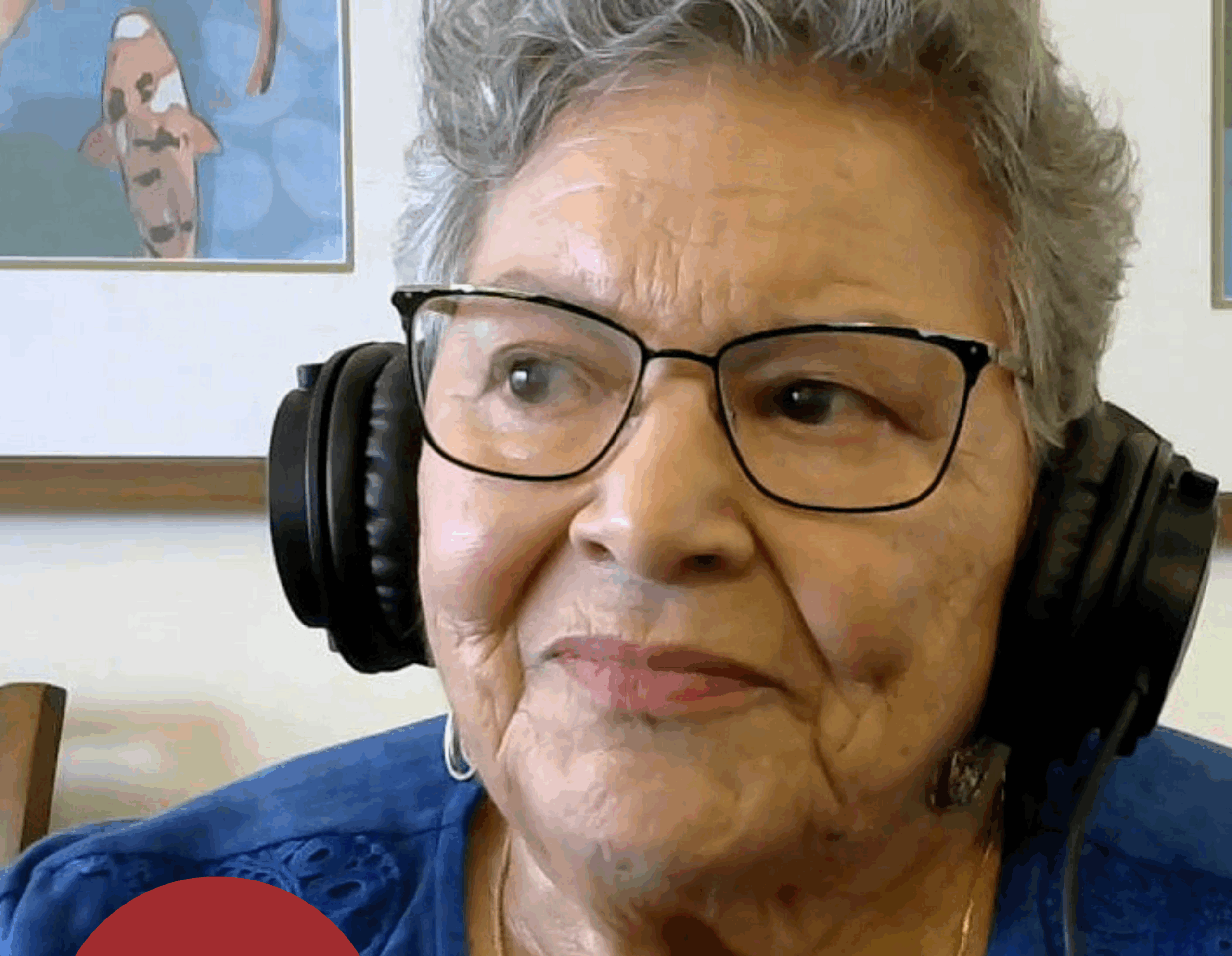An older woman wearing headphones looks off screen.
