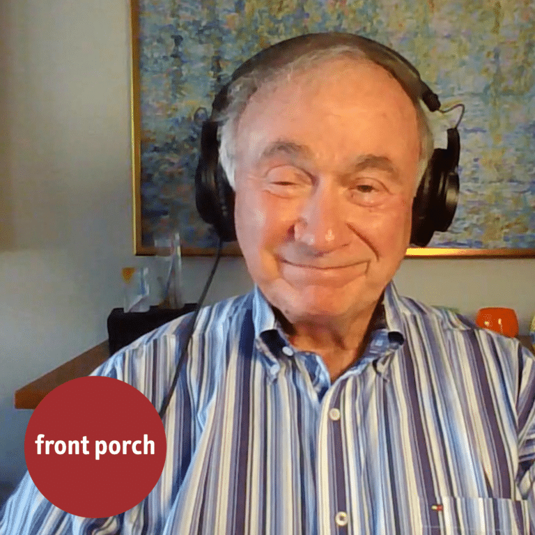 An Older Man Smiles While Wearing Headphones.