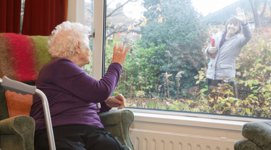 ladies waving to each other from a window