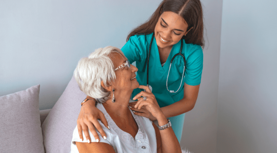 a nurse and an old lady smiling each other