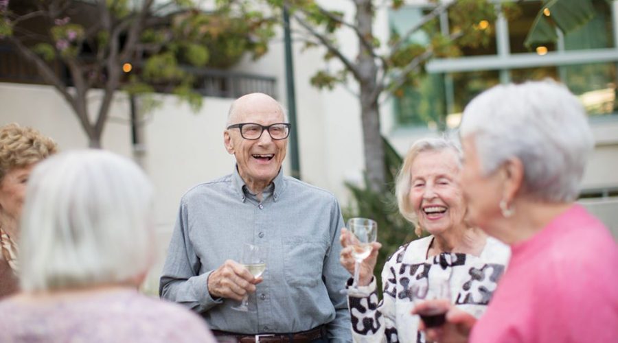 a group of elderly people drinking a glass of wine and celebrating