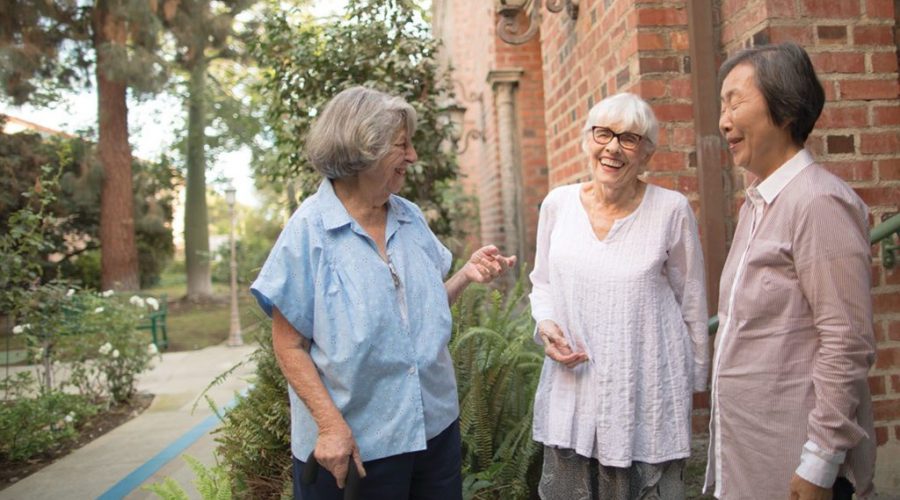 three senior ladies talking and laughing in front of an independent living