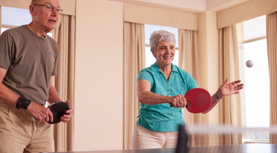 an elderly couple playing ping pong