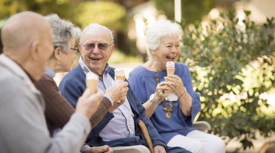 a group of elderly people sharing together and eating ice cream