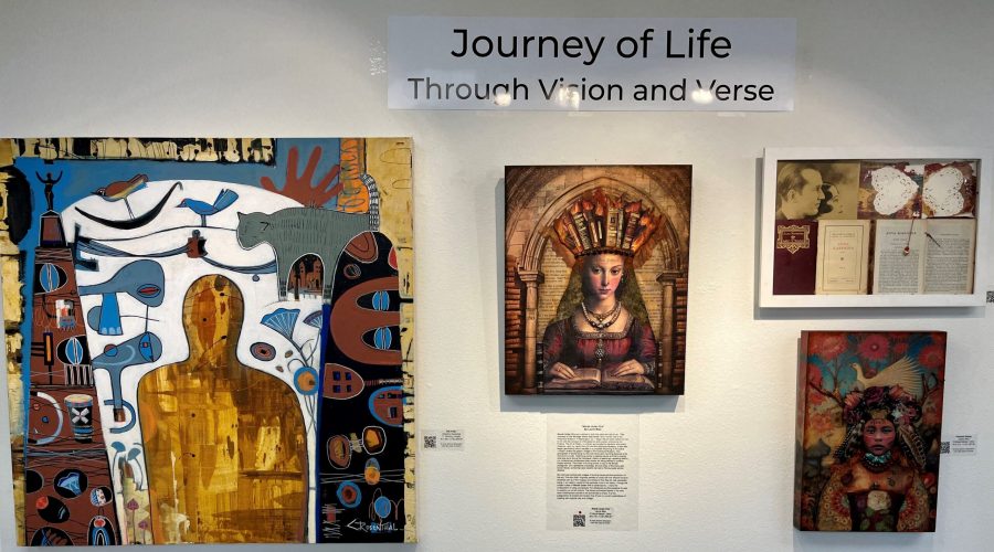 Artworks hung on a white wall. Sign above says Journey of Life.