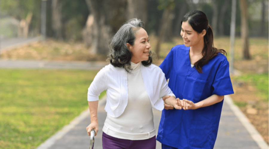 nurse walking with an elderly lady