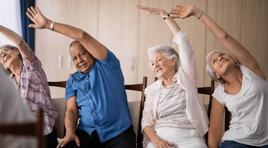 A group of older adults sitting and stretching.