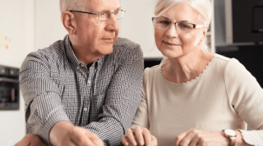 elderly couple signing a paper