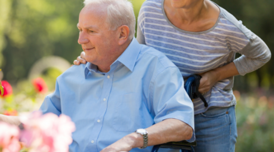 Woman pushing elderly man in a wheelchair